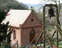 Die Glocke vor der kleinen Kapelle auf dem historischen Friedhof in Stolpe